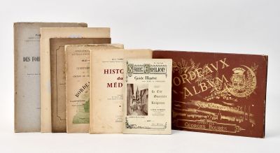 several old books sitting on top of each other on a white surface