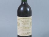 an old bottle of wine sitting on top of a table