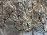 a close up of a wedding dress with gold and silver sequins