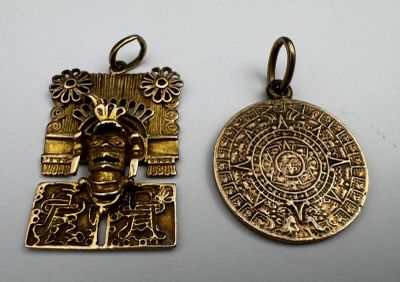 two gold pendants of a man with a medallion on it