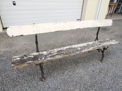 un banc en bois posé devant un garage