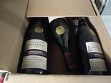 two bottles of wine in a box on the floor