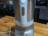 a silver blender sitting on a wooden table