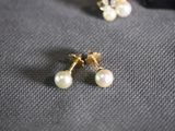 a close up of a pair of pearl earrings on a cloth