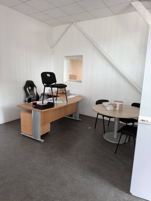 a room with a desk, chairs, and a chair in it