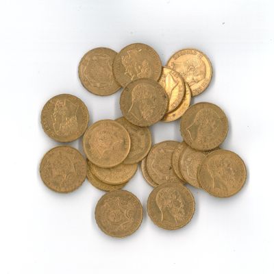Des pièces d'or sont éparpillées sur une surface blanche, sur fond blanc