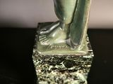 a close up of a statue of a bird on a base
