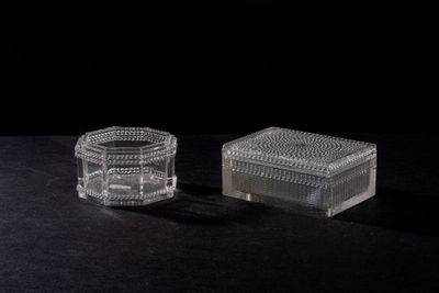 two clear glass containers sitting on top of a black surface