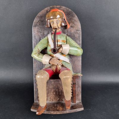 statue of a man sitting on a chair with a pipe in his hand