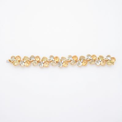 un bracelet en or orné de pierres jaunes et blanches sur fond blanc
