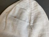 a white hat with a tassel on it on a table
