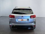the rear end of a silver citrole parked in a white room
