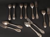many forks and spoons laid out on a table