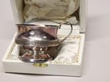 a silver cup that is in a box on a table