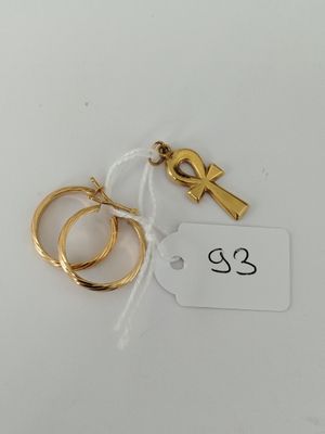 a close up of two gold rings and a tag on a white surface