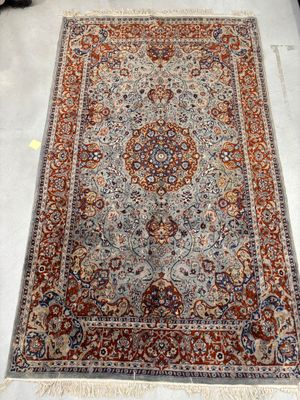 un grand tapis persan orné d'un motif en médaillon sur fond blanc