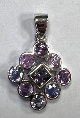un gros plan d'un pendentif violet et bleu sur une surface blanche