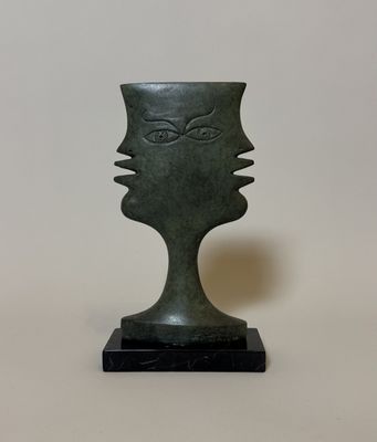 sculpture représentant un visage sur un socle noir, avec un fond blanc