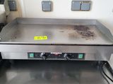 une photo d'une plaque de cuisson à gaz professionnelle dans une cuisine professionnelle
