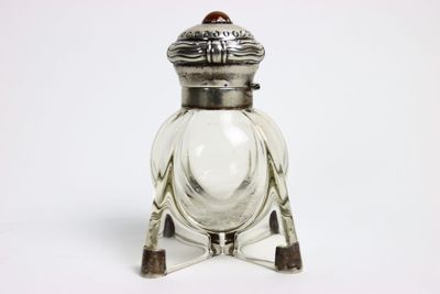 une image représentant une salière en argent et en verre sur fond blanc