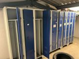 Plusieurs casiers bleus sont alignés les uns à côté des autres dans un garage