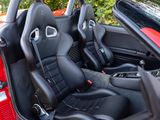the interior of a red sports car with black leather seats