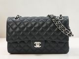 un sac Chanel noir auquel est suspendue une chaîne