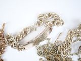 a lot of silver and gold chains on a white surface