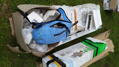 a blue bag sitting on top of a cardboard box on the grass