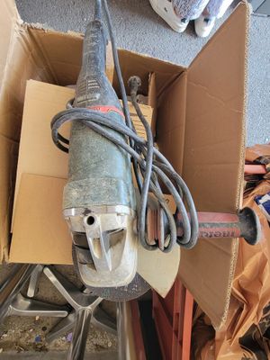 une boîte contenant une perceuse et une boîte à outils posées par terre