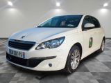 La voiture blanche est garée sur le sol à damier du garage.