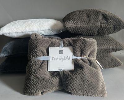 several pillows are stacked on top of each other on a table