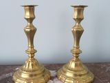 pair of brass candlesticks sitting on a marble table