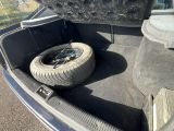 a tire in the trunk of a car that is parked