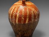 un vase marron posé sur une surface grise