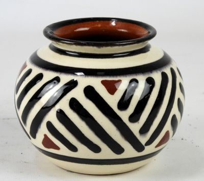 a black and white vase sitting on a white surface