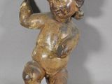 une petite statue représentant un garçon tenant un couteau