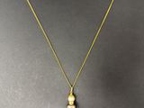 un collier en or orné d'un pendentif en perle