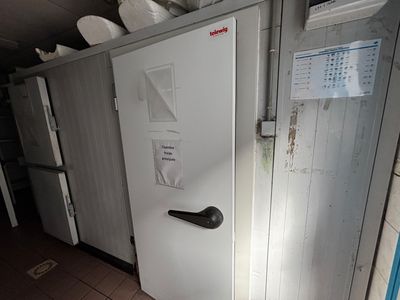 un réfrigérateur blanc au milieu d'une pièce, avec beaucoup de vaisselle posée dessus
