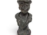 bronze bust of a boy with a hat on a wooden base