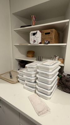 une pile de récipients en plastique posée sur un plan de travail dans une cuisine
