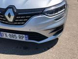 the front end of a silver car with a black stripe on it