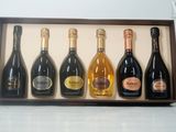 cinq bouteilles de vin dans un coffret en bois posé sur une table