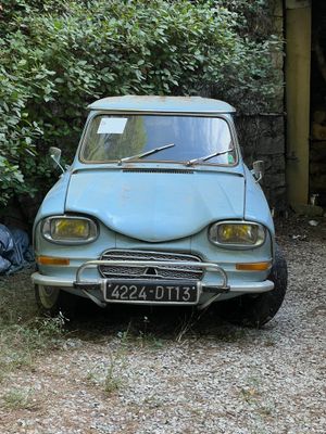 une petite voiture bleue garée devant un immeuble
