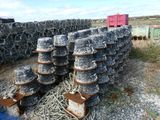 un tas de casiers à homards posé par terre à côté d'un conteneur rouge