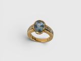 a gold ring with a blue topaz stone and diamonds