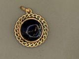 a close up of a gold pendant with a clock on it