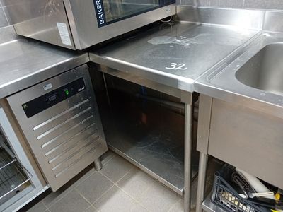 une petite cuisine équipée d'appareils électroménagers en inox et d'un évier