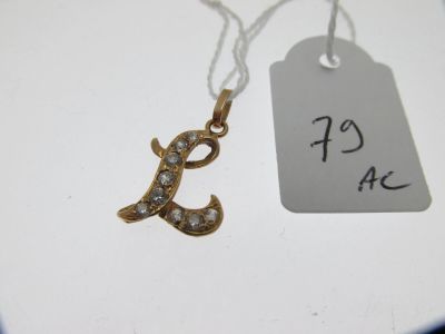 un petit collier en or orné d'une initiale en diamant