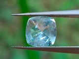 un gros plan d'un diamant bleu tenu par une paire de pinces